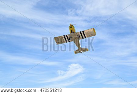 Yellow Single-engine Ultralight Airplane Flying In The Blue Sky With White Clouds