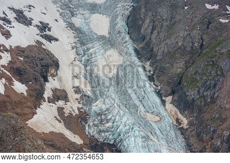 Atmospheric Mountain Landscape With Long Vertical Glacier Tongue With Cracks Among Rocks. Awesome Ae