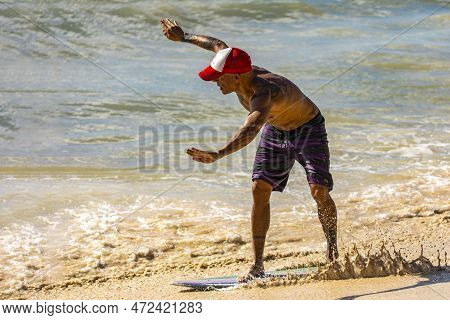 Playa Del Carmen, Mexico - March 10, 2023: Man Practicing Skimboarding Which Is A Modality That Is P