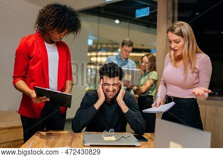 Portrait Of Overworked Team Leader Under Stress Sitting At Table With Laptop Holding Pain Head. Fema