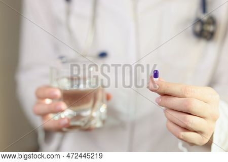 Woman Doctor Shows Single Pill In Her Hand Close-up. Right Dose Of Medicine, Vitamins And Health Car