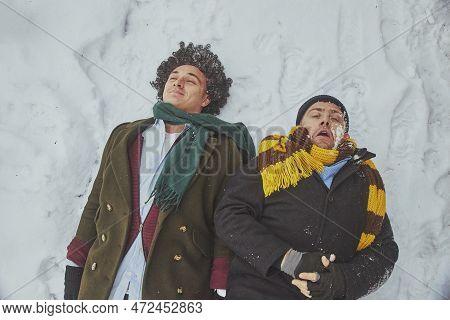 Skive, Denmark, December 2022: Two Men Fell On Their Backs In Winter
