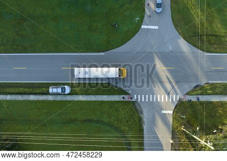 Aerial View Of American Yellow School Bus Picking Up Children At Sidewalk Bus Stop For Their Lessong