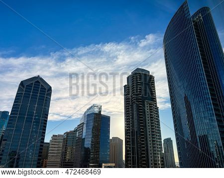 Modern Skyscrapers Gleam Under A Deep Blue Sky Accentuated By White Clouds. High Quality Photo