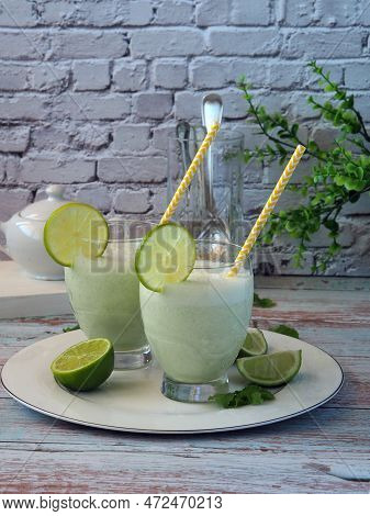 Glasses With Traditional Brazilian Lemonade Or Limeade With Mint And Lime Slices On White Background