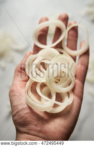 Ring Sliced Onions On Mans Hand. Photo Show How Does Onion Sliced Into Thin And Thick Rings Look Lik