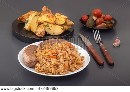Braised Cabbage - Bigos And Grilled Sausage In A White Porcelain Plate Against The Background Of Rus
