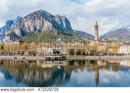 Sunny Aerial Cityscape Of Lecco Town On Spring Day. Picturesque Waterfront Of Lecco Town Located Bet