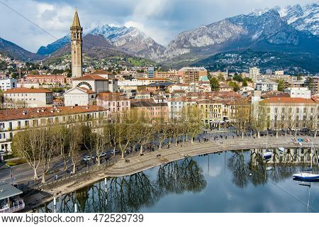 Sunny Aerial Cityscape Of Lecco Town On Spring Day. Picturesque Waterfront Of Lecco Town Located Bet
