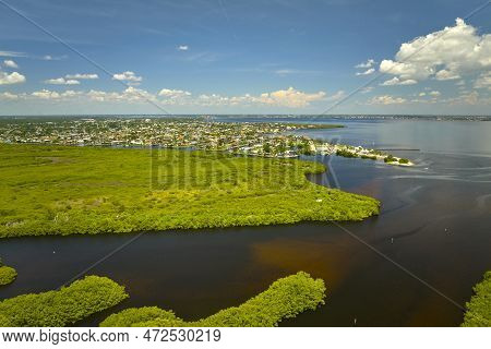 Overhead View Of Everglades Swamp With Green Vegetation Between Water Inlets And Rural Private House