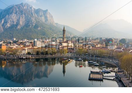 Foggy Aerial Sunrise Cityscape Of Lecco Town On Spring Day. Picturesque Waterfront Of Lecco Town Loc