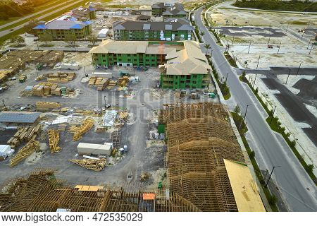 View From Above Of Unfinished Frame Of Apartment Condos With Wooden Roof Beams Under Construction. D