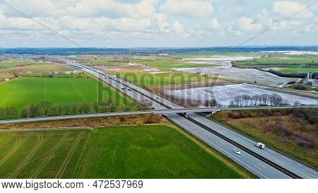 Aerial View Of A Drone On The A7 Motorway In Northern Germany Between Fields And Meadows.