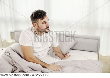 A Morning Man Waking Up In The Morning And Looking Trough The Window.