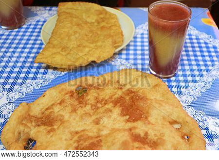 Bolivian Bunuelos Fried Dough With Api Morado, Beverage Made From Purple Corn