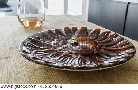 A Plate Of Slices Of Iberic Ham On A Plate And A Glass Of Wine On A Table In The Kitchen. Spanish Tr