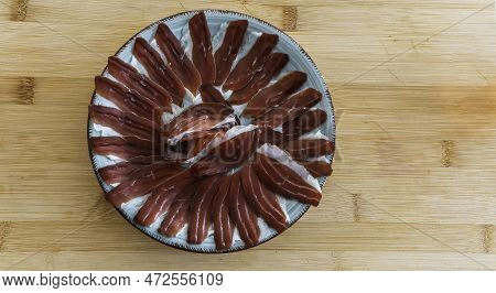 A Plate Of Slices Of Iberic Ham On A Plate Sitting On Top Of A Wooden Table . Spanish Traditional Ja