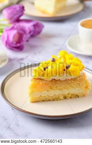 Sliced Biscuit Cake With Cream Cheese Cream, Lemon Layer And Yellow Biscuit Decor On A Ceramic Plate