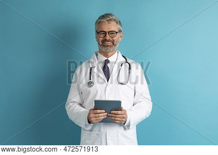 Friendly Middle Aged Doctor Holding Digital Tablet, Copy Space