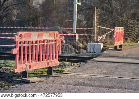 Closed Railway Tracks Under Construction Or Maintenance Of A Crossing With A Road. Reflection Orange