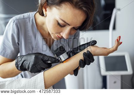 Doctor Dermatologist Examines Skin Of Client Face Of Beauty Salon With A Dermatological Lens. Dermat