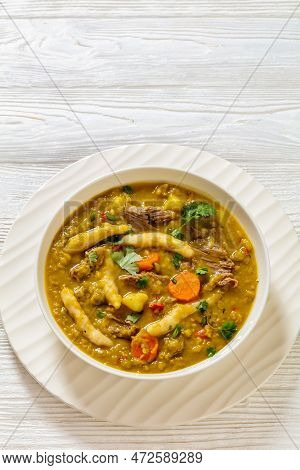 Gungo Peas, Pigeon Peas Soup With Dumplings , Vegetables And Beef In White Bowl On White Wood Table,