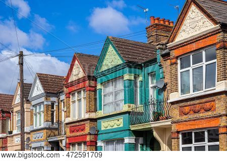 A Row Of Colourful Terraced Houses Around Kensal Rise In London With Overhead Cable Lines