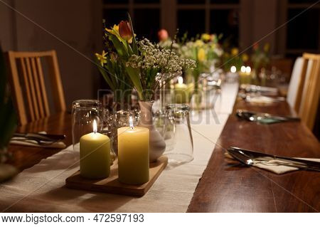Table Setting For A Large Dinner Party With Family And Friends Decorated With Candles, Spring Flower