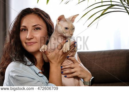 Portrait Of Young Woman Holding Cute Cat With Blue Eyes. Female Hugging Her Cute Short Hair Kitty. B