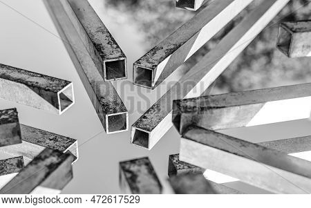 The Ends Of Several Rusted Square Pipes Converge At One Point. Focus On The Ends Of The Two Pipes. A