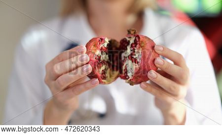 Female Dietologist Show Pomegranate Fruit In Her Hand Close Up. Concept Of Healthy Food With Vitamin