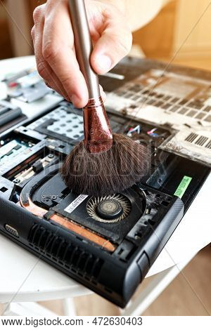 Repaiman With Brush Is Cleaning Disassembled Laptop Parts. Technical Support And Fixing Gadgets Prob