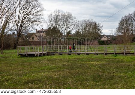 Uccle, Brussels Capital Region, Belgium, March 4, 2023 - Mother And Sun Walking Through The Keyenbem