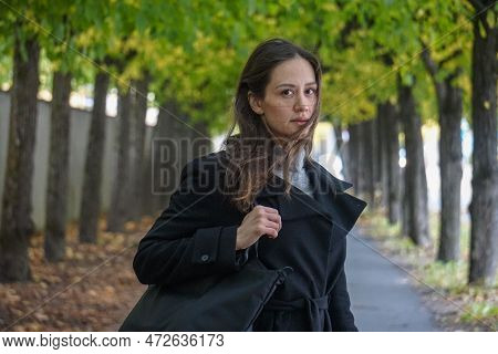 Portrait Of Young Woman Standing Admist Trees On A Street