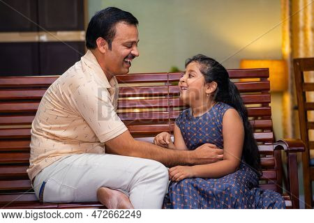 Happy Smiling Father Playing With Daughter By Tickling While Sitting On Sofa At Home - Concept Of Re