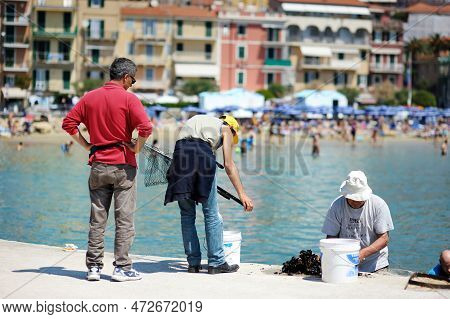 San Terenzo, Italy - May 2011: Tourists And Locals Watching Fishermen In Small Fishing Boat With Equ