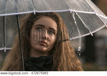 Portrait Of A.ttractive Pensive Young Woman With Lush Brown Hair Under Transparent Umbrella. Autumn 