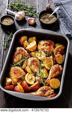 Lemon Garlic Chicken With Roasted Potatoes, Spices And Herbs On Sheet-pan On Dark Wood Table With Ng