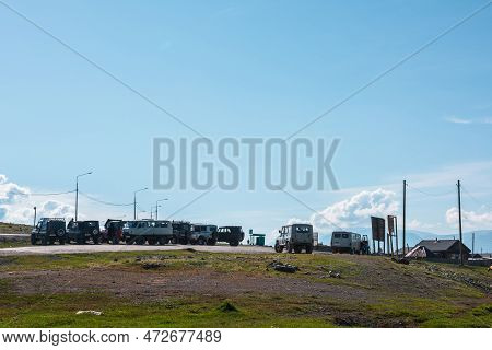 Lots Of Russian Off-road Vehicles Parked By Road Near Kurai Mountain Village At Sunny Day. Group Of 