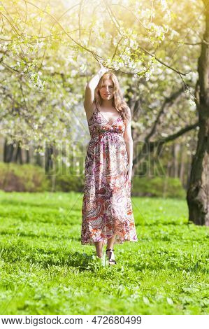 Modern Lifestyle Concepts. Portrait Of Winsome Blond Caucasian Adult Girl Posing Outside In Green Fo