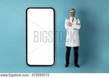 Handsome European Doctor Pointing At Huge Phone With White Screen