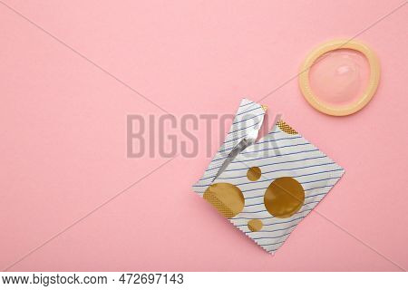 Opened Condom In Pack On Pink Background. A Condom Use To Reduce The Probability Of Pregnancy Or Sex
