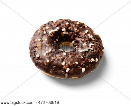 One Donut In Chocolate Glaze Sprinkled With Pieces Of White, Milk And Dark Chocolate Isolated On A W