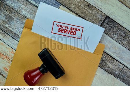 Concept Of Red Handle Rubber Stamper And You've Been Served Text Isolated On On Wooden Table.