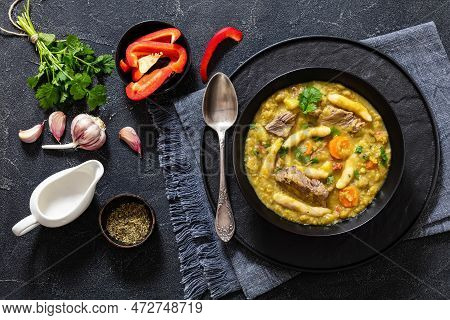 Gungo Peas, Pigeon Peas Soup With Dumplings And Beef In Black Bowl On Concrete Table With Ingredient