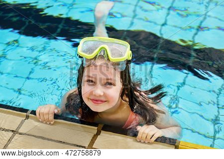 Cute Happy Young Girl In Goggles Swimming And Snorking In The Swimming Pool. Happy Child In Summer I