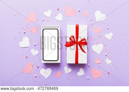 Opened Gift Box With Ribbon And Phone On Color Background, Top View. Blank Open Box Packaging Mockup