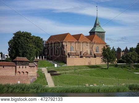 Kosciol Rzymskokatolicki Pw. Sw. Jana Chrzciciela Church In Malbork With Nogat River At Sunny Day In