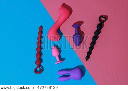 Top View Of Buttplugs And Dildos Vibrator For Sex On Colored Background. Sex Shop Concept