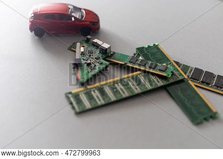 Toy Cars On An Electronic Board With Integrated Circuits. The Shortage Of Microchips And Semiconduct